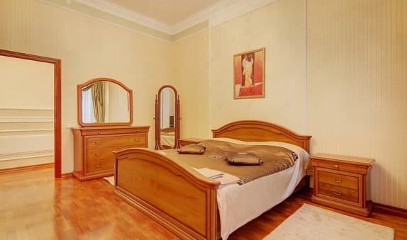 Спальня с деревянной кроватью и картиной на стене